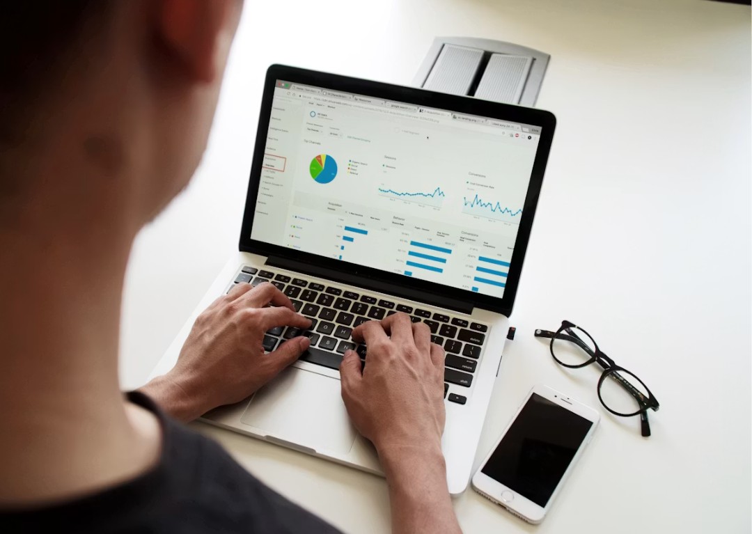 Persona analizando métricas y reportes de campañas publicitarias en una laptop