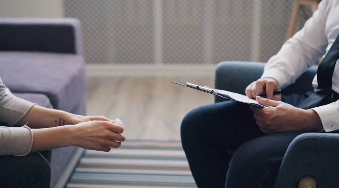 Profesional de la salud tomando notas durante una consulta con un paciente